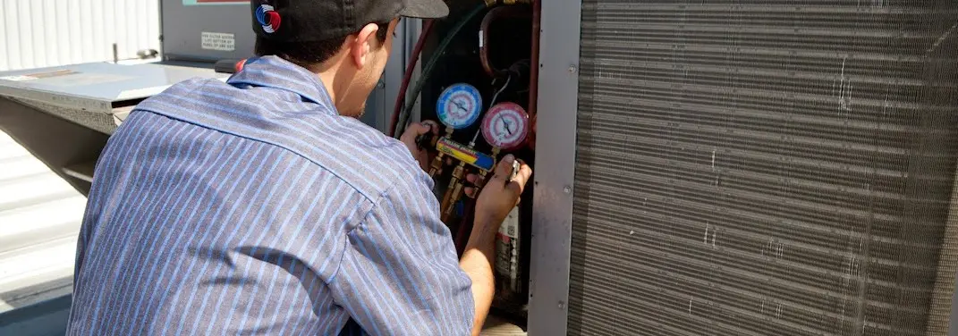 HVAC technician servicing a condenser unit in Kentfield